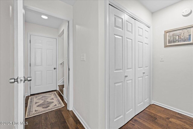 hallway featuring dark wood finished floors and baseboards