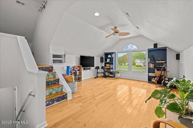 recreation room featuring lofted ceiling, wood finished floors, a textured ceiling, and baseboards