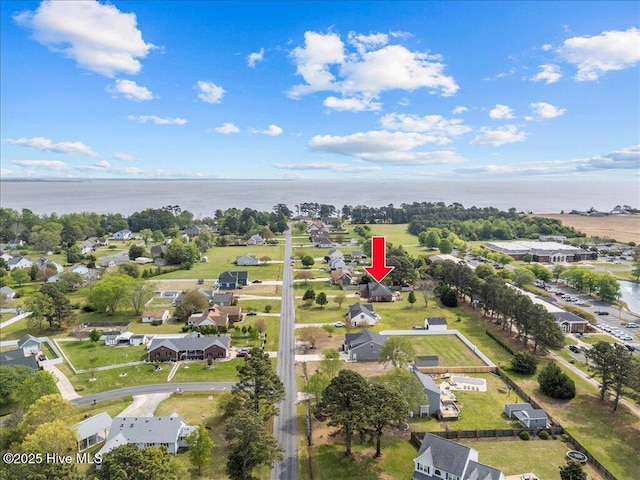 aerial view of property and surrounding area with a large body of water and nearby suburban area