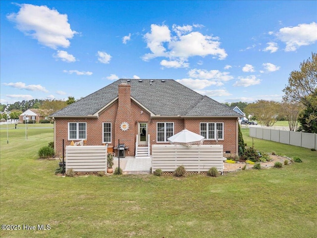 rear view of property with brick siding, roof with shingles, and a chimney