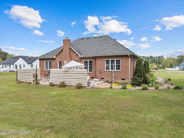 rear view of house with crawl space, brick siding, a yard, and a chimney