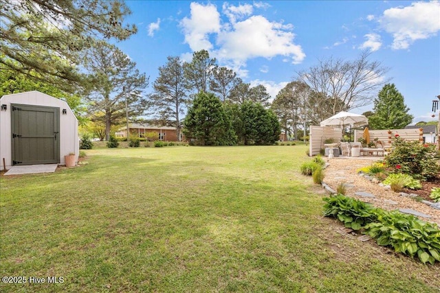 view of green lawn featuring a storage shed and an outbuilding