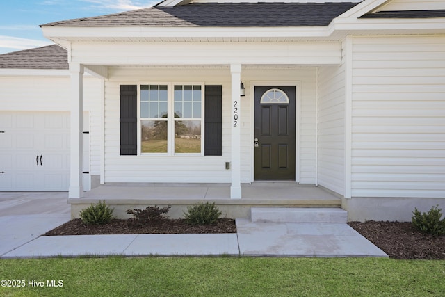 entrance to property with a porch, a shingled roof, and a garage