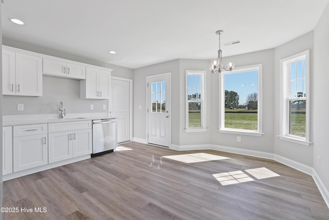 kitchen featuring a sink, baseboards, visible vents, an inviting chandelier, and dishwasher