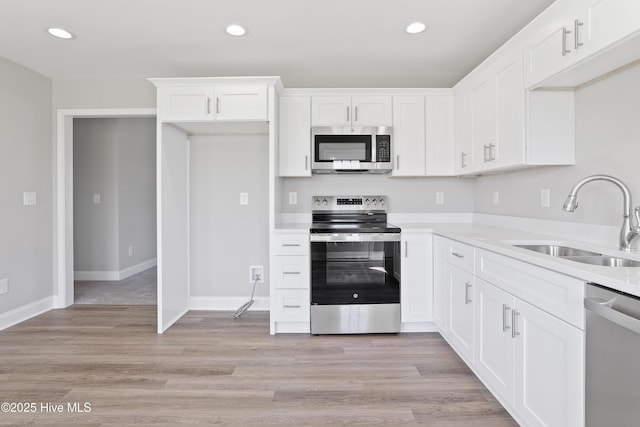 kitchen featuring white cabinets, appliances with stainless steel finishes, a sink, and recessed lighting