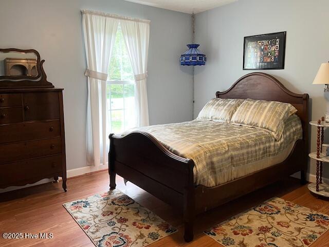 bedroom with baseboards and wood finished floors