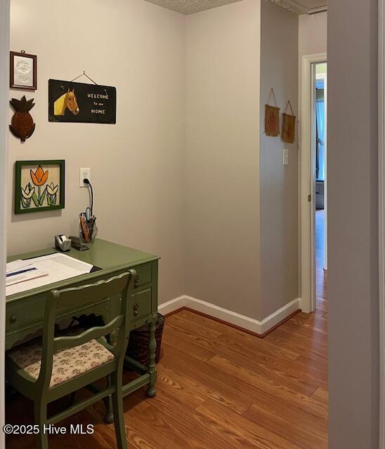 office area featuring baseboards and wood finished floors