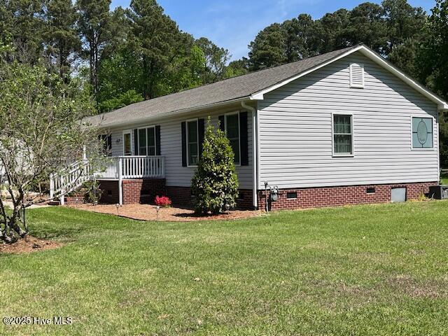 exterior space featuring a porch, a yard, and crawl space