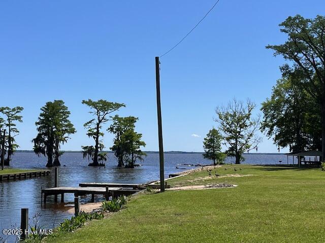 exterior space with a lawn, a boat dock, and a water view