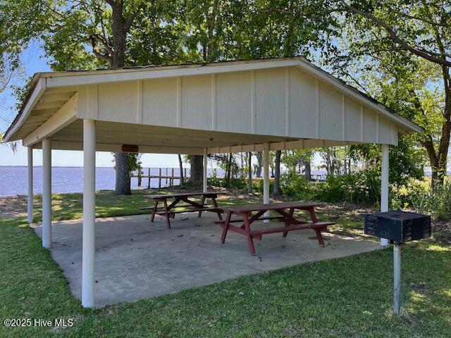 view of community featuring a gazebo, a water view, a lawn, and a patio