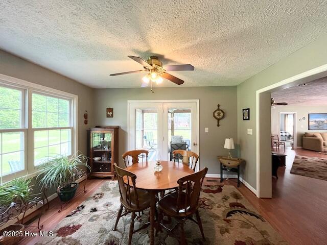dining area featuring a ceiling fan, plenty of natural light, and wood finished floors