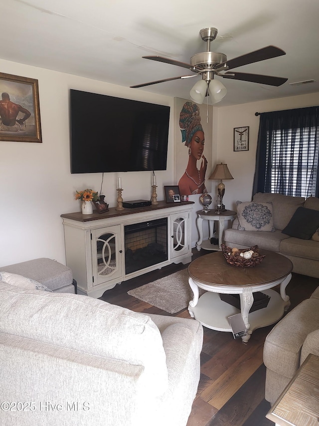 living area featuring a ceiling fan and wood finished floors