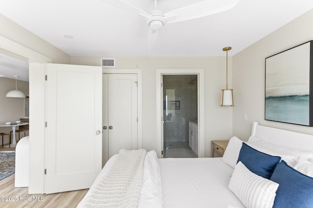 bedroom featuring light wood-type flooring, connected bathroom, and a closet
