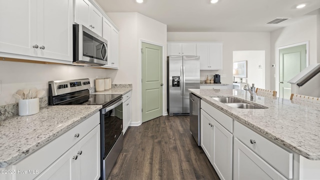 kitchen with a sink, stainless steel appliances, dark wood finished floors, white cabinetry, and visible vents