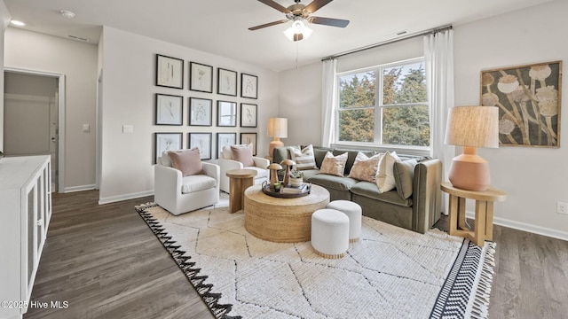 living area featuring wood finished floors, visible vents, a ceiling fan, and baseboards