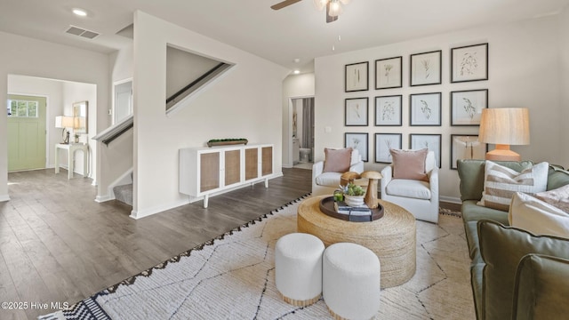 living area with wood finished floors, visible vents, baseboards, and ceiling fan