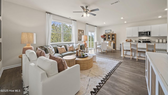 living area with a ceiling fan, baseboards, dark wood-type flooring, visible vents, and recessed lighting
