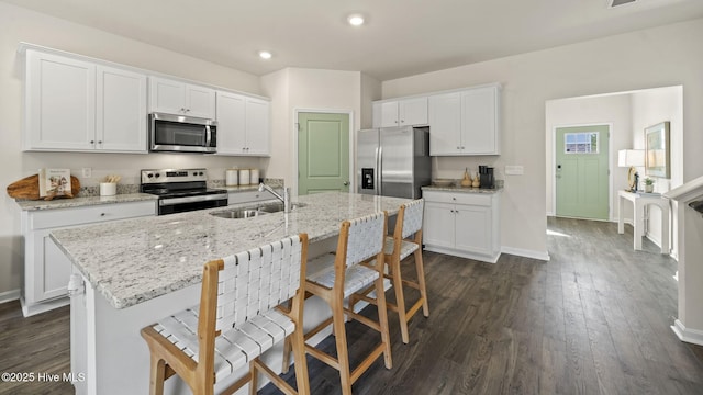 kitchen with white cabinets, stainless steel appliances, a sink, and recessed lighting
