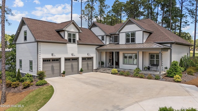 100 Holly Springs Ct, Southern Pines, NC 28387 - view of front of home with a standing seam roof, covered porch, an attached garage, a shingled roof, and concrete driveway