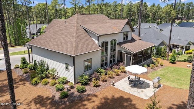 100 Holly Springs Ct, Southern Pines, NC 28387 - back of property featuring roof with shingles, a sunroom, a patio area, and a lawn