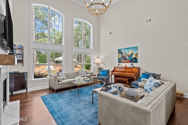100 Holly Springs Ct, Southern Pines, NC 28387 - living area featuring baseboards, dark wood-style flooring, an inviting chandelier, and a high ceiling