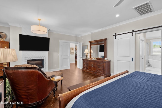 100 Holly Springs Ct, Southern Pines, NC 28387 - bedroom featuring crown molding, a tiled fireplace, visible vents, and wood finished floors