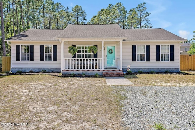 197 Cherry Rd, Southport, NC 28461 - view of front of home with covered porch, crawl space, fence, and roof with shingles