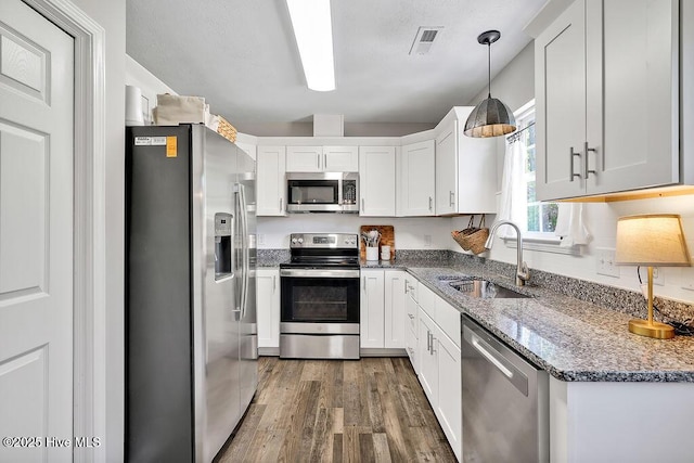 197 Cherry Rd, Southport, NC 28461 - kitchen featuring appliances with stainless steel finishes, a sink, wood finished floors, and white cabinets