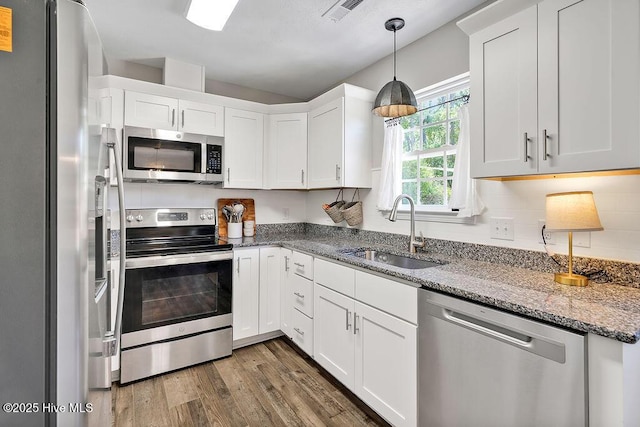 197 Cherry Rd, Southport, NC 28461 - kitchen featuring stainless steel appliances, a sink, wood finished floors, and white cabinetry