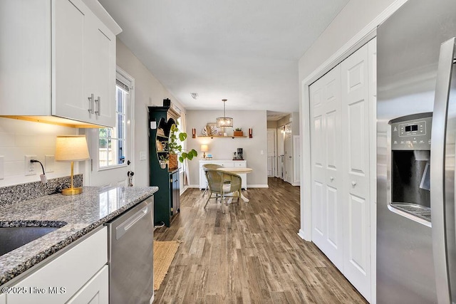 197 Cherry Rd, Southport, NC 28461 - kitchen featuring appliances with stainless steel finishes, wood finished floors, white cabinets, light stone counters, and decorative light fixtures