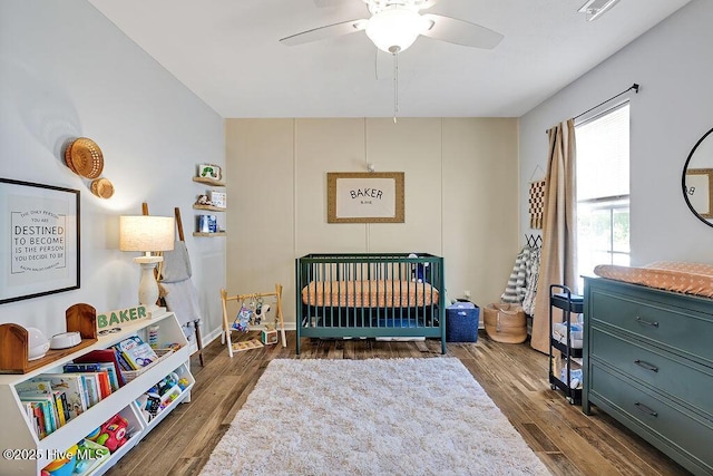 197 Cherry Rd, Southport, NC 28461 - bedroom featuring a nursery area, wood finished floors, and ceiling fan