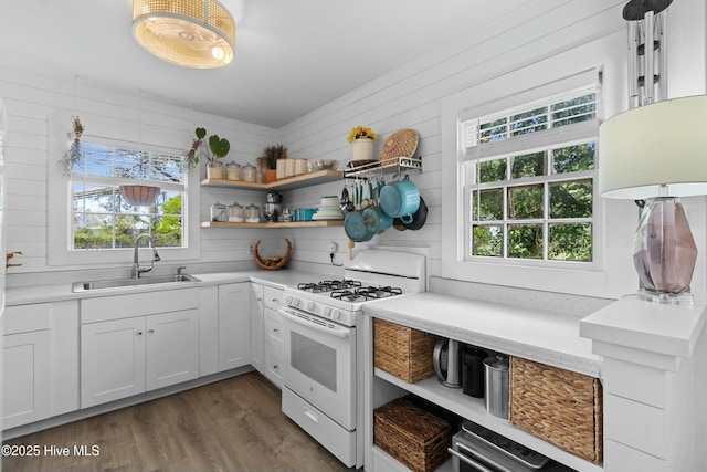 kitchen with white range with gas cooktop, a sink, and open shelves