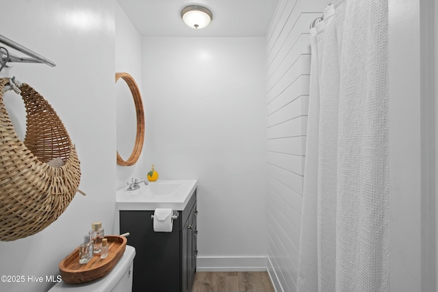 bathroom featuring toilet, vanity, and wood finished floors