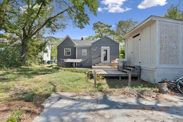back of property with a lawn and entry steps