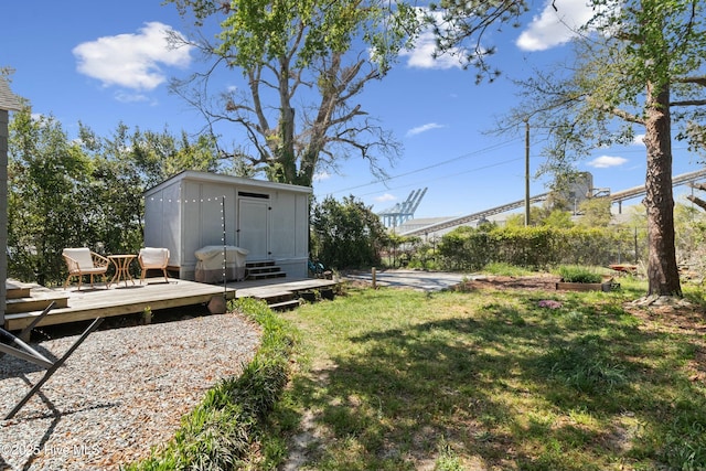 view of yard with an outbuilding, a shed, and a wooden deck