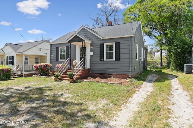bungalow-style house with crawl space, driveway, central AC, a chimney, and roof with shingles
