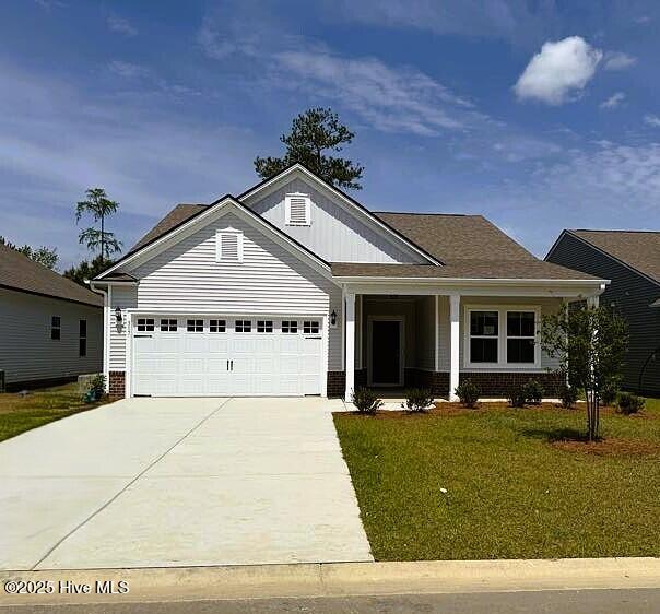317 Eagle Claw Dr Unit 4033, Carolina Shores, NC 28467 - view of front of property featuring driveway, a front lawn, a garage, board and batten siding, and brick siding