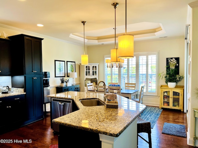 2208 Drawing Ct, Wilmington, NC 28412 - kitchen with dark wood-type flooring, a tray ceiling, crown molding, an island with sink, and a kitchen breakfast bar