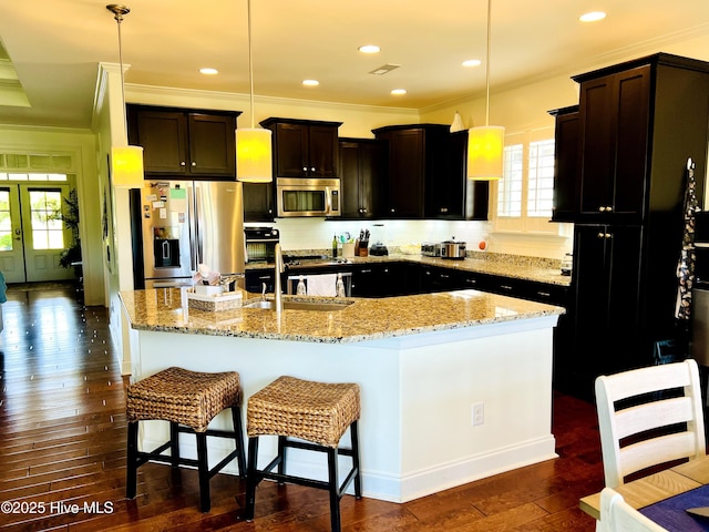 2208 Drawing Ct, Wilmington, NC 28412 - kitchen with stainless steel appliances, dark wood-style floors, an island with sink, backsplash, and crown molding
