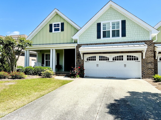 2208 Drawing Ct, Wilmington, NC 28412 - craftsman-style house with a porch, driveway, board and batten siding, an attached garage, and a front yard