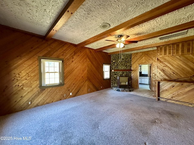 119 Emperor Landing Rd, Edenton, NC 27932 - unfurnished living room with carpet flooring, beam ceiling, visible vents, wood walls, and ceiling fan