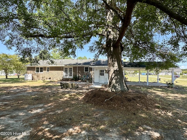 119 Emperor Landing Rd, Edenton, NC 27932 - view of front facade featuring brick siding, a carport, a patio area, and french doors