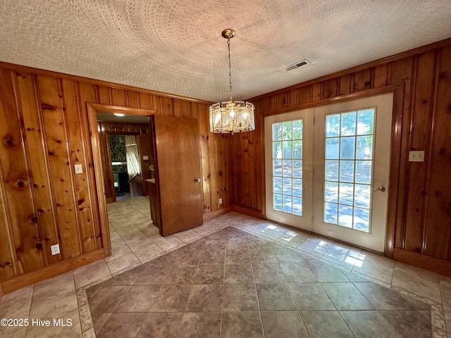 119 Emperor Landing Rd, Edenton, NC 27932 - unfurnished dining area with tile patterned flooring, visible vents, wood walls, and a notable chandelier