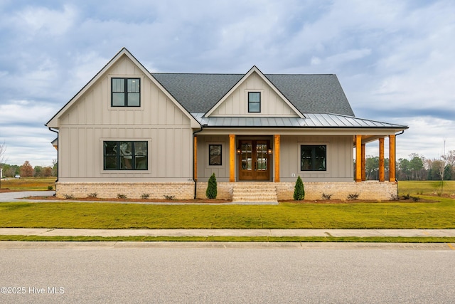 modern farmhouse style home with a standing seam roof, a front lawn, a porch, metal roof, and board and batten siding