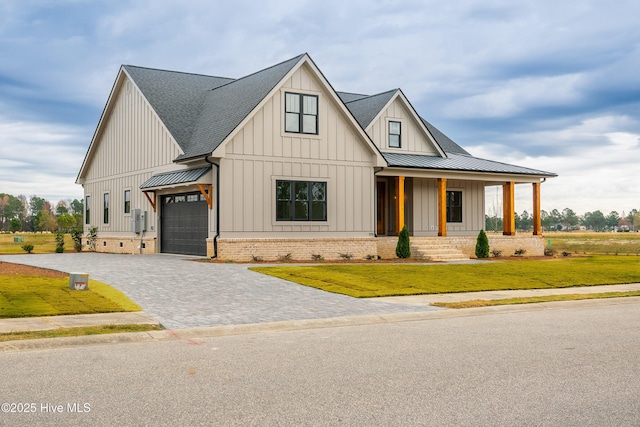 modern inspired farmhouse featuring a standing seam roof, a front lawn, a porch, board and batten siding, and decorative driveway