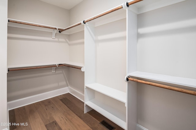 walk in closet with wood finished floors and visible vents