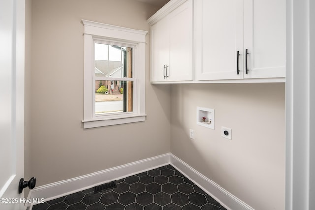 laundry room with hookup for a washing machine, dark tile patterned flooring, hookup for an electric dryer, cabinet space, and baseboards