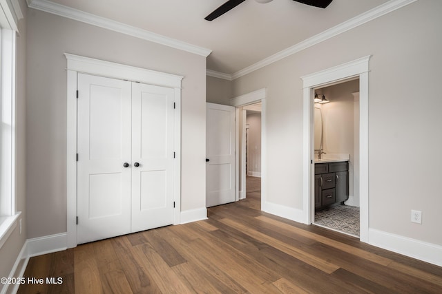 unfurnished bedroom featuring baseboards, crown molding, and wood finished floors