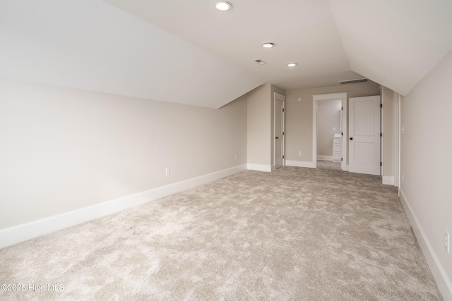 additional living space with vaulted ceiling, light carpet, baseboards, visible vents, and recessed lighting