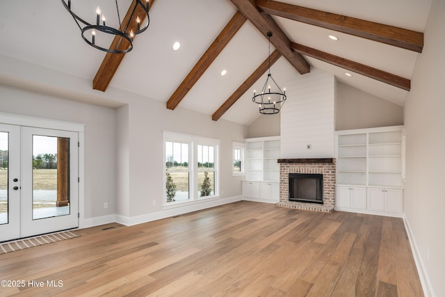 unfurnished living room with french doors, beam ceiling, light wood-type flooring, an inviting chandelier, and recessed lighting